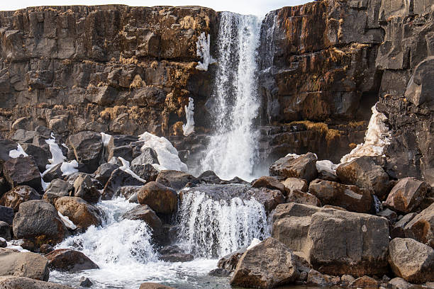 þingvellir National Park is a part of the Golden Circle of Iceland. Situated on the north shore of Lake Thingvallavatn, it's only 30 miles east of Reykjavik  . Walking between two tectonic plates. Oxararfoss waterfall in winter.