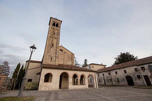 Tempio di Ormelle, Treviso, Italy: wide-angle horizontal view of the medieval Templar complex. The image captures the Chiesa di San Giovanni Battista with its tall bell tower and portico, alongside the historic \