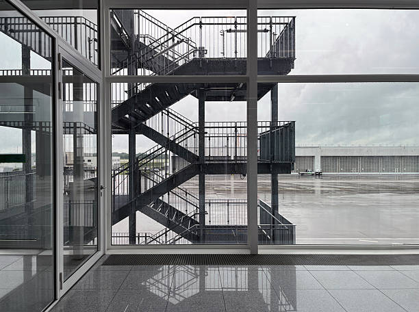 Modern airport interior with large windows and a view of the staircase structure