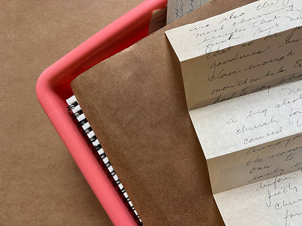 Pink plastic container with papers and old letter folded accordion style.