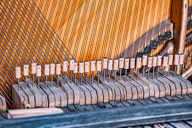 Close up of an old, abandoned piano's internal components, showing the soundboard, strings, and hammer mechanism
