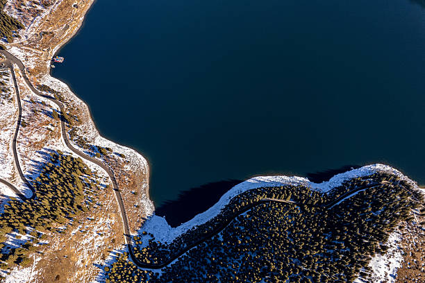 Deep blue lake water in the snow under the high mountains