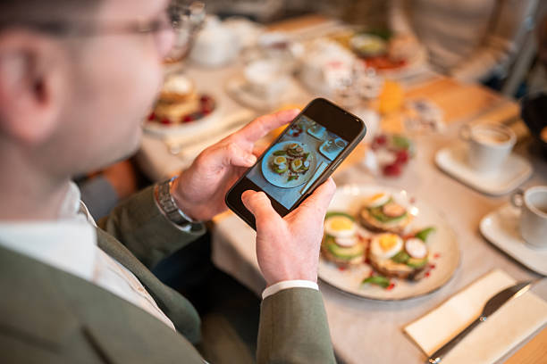 istock Young Adult Male Documenting Brunch Meal Using Smartphone Camera 2256833036