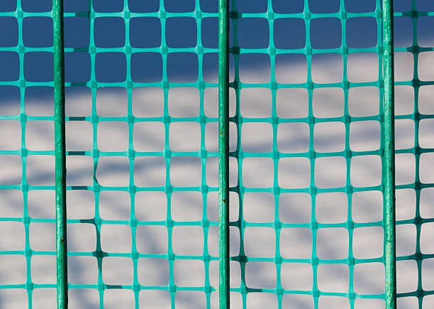 A beautiful layer of frost coats the wooden panels of a fence, set in an outdoor environment that showcases the textures of winter conditions