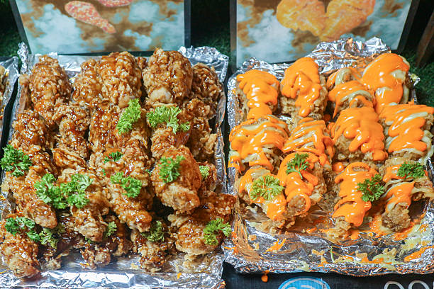 Crispy fried chicken with spicy mayo and cheese sauce. Modern Thai fusion street food in a vibrant local market.