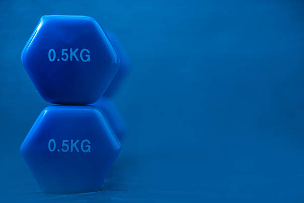 Two blue 0.5kg dumbbells stacked on a blue background, symbolizing light strength training