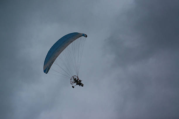A powered paragliding is flying in the sky