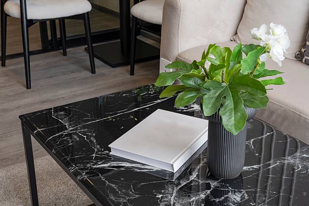 Minimalist living room interior with black marble coffee table and white book.