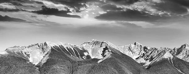 Black and white panoramic view on snowy mountains and cloudy sky in evening. Caucasus Mountains. Svaneti region of Georgia.
