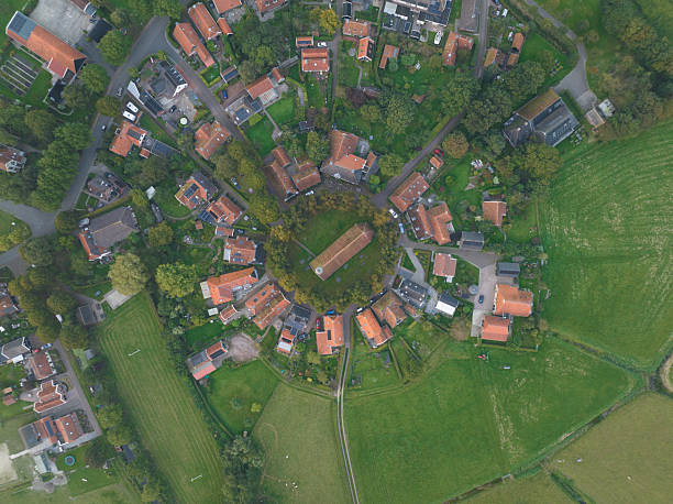 Den hoorn village on texel island, netherlands, showcasing residential houses with red roofs arranged in a distinctive circular pattern surrounding a central church, surrounded by green fields