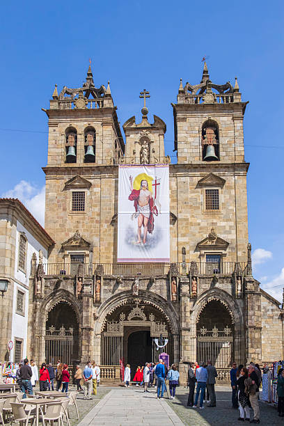 Tourists strolling in front of the Braga Cathedral, consecrated in 1089, on whose facade stands out an image of the risen Christ that recalls Easter and the Holy Week (Semana Santa)