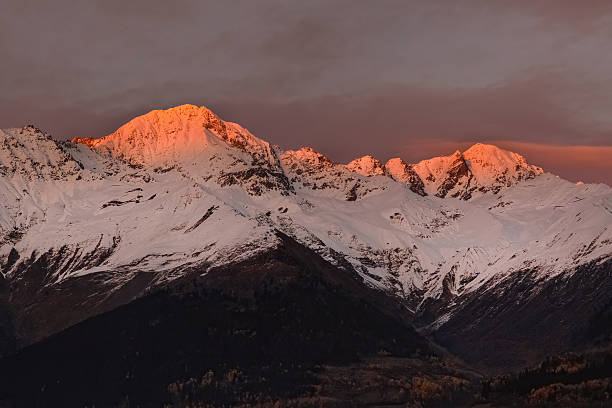 A view of Mount Lougheed, on the left, and The Three Sisters Mountains, on the right, in Canmore, Alberta, Canada, at sunrise.