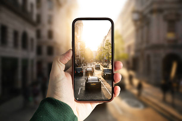 A smartphone showing cars in a city street at sunset