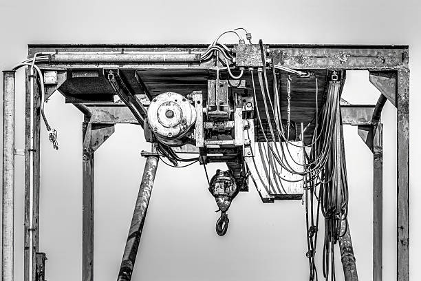Old industrial gantry crane with hoist and wires. Metal structure showing rust and mechanical parts in Tolkamer, Netherlands