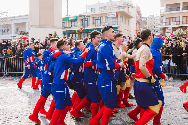 Xanthi, Greece - February 18, 2018: Participants dressed as Captain America and Wonder Woman march together during the annual Xanthi Carnival parade as crowds line the streets to watch the colorful celebration, one of the most famous carnival events in northern Greece