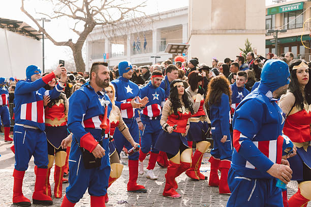 Xanthi, Greece - February 18, 2018: Participants dressed as Captain America and Wonder Woman march together during the annual Xanthi Carnival parade as crowds line the streets to watch the colorful celebration, one of the most famous carnival events in northern Greece