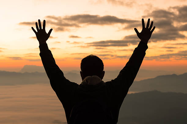 istock Silhouetted hiker raises hands in celebration on a mountain peak at sunrise. A powerful conceptual image of freedom, success, personal achievement and inspiration in nature beauty. 2256864168