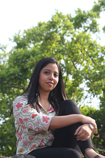 istock Young woman crouching and looking at camera in a park 2256866450
