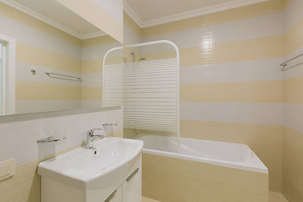 Shower stall in the bath next to the closet, toilet and washbasin in the bathroom. High quality photo