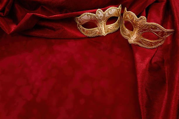 istock Golden masquerade masks resting on red velvet drapery 2256898438