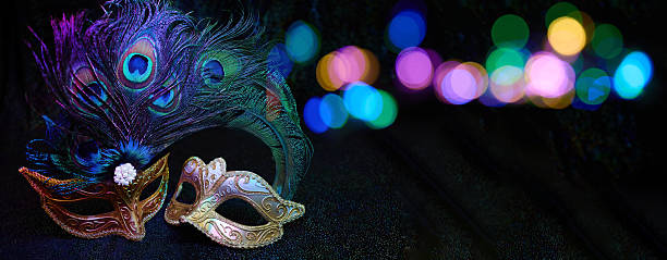 Two ornate masquerade masks with peacock feathers celebrating carnival with vibrant bokeh lights