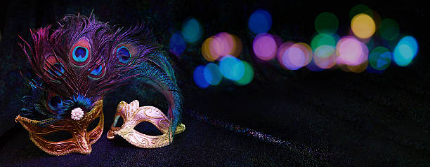 Venetian masquerade masks with decorative feathers and sparkling bokeh lights on a dark background