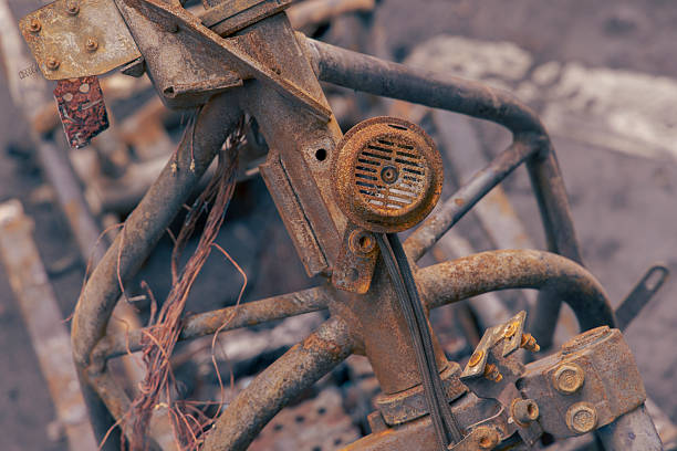 Grim aftermath of burned-down motorcycles left on a city street. The image displays the charred skeletons and melted remains of motorbikes amidst ash and debris.