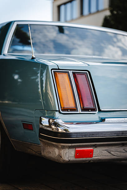 Focused shot of a classic car tail light highlighting shiny metal details and red lens capturing timeless automotive design and craftsmanship.