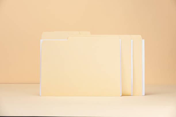 File folders with papers on pale yellow background