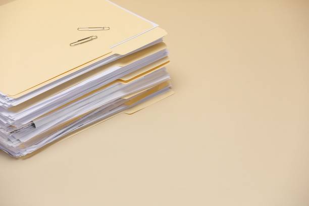 File folders with documents and paper clips on pale yellow background, closeup. Space for text