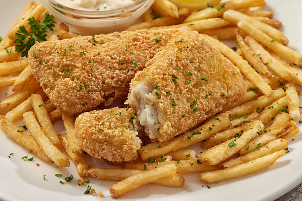 Cut Tempura battered fish served with french fries, tartar sauce, and lemon.