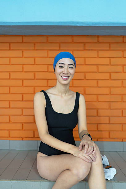 Happy woman swimmer resting poolside