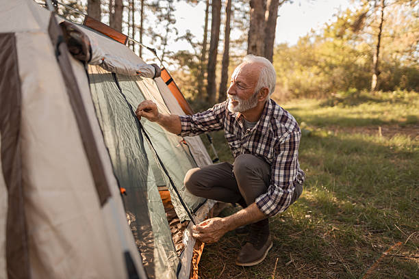 istock Senior man setting up tent while camping in nature 2256911855