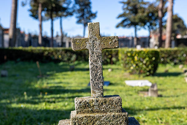 A cemetery with many gravestones and a few flowers. Scene is somber and peaceful