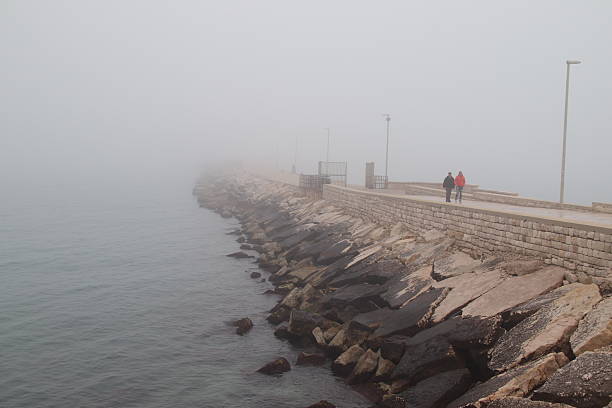 Trani, Province of Barletta-Andria-Trani, Italy - 18 january 2026: The pier of San Nicola shrouded in fog.
