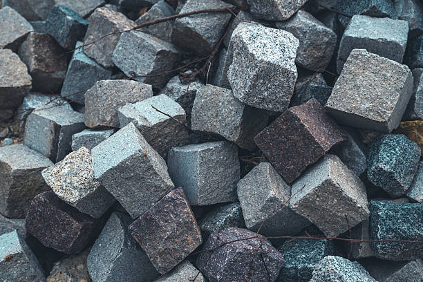 Pile of rough granite cobblestone blocks close-up texture