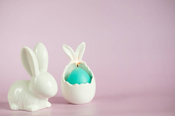 Decorative Easter Bunny and Egg with Surprise on Pink Background. A cheerful spring composition, a symbol of Easter, a minimalistic festive decor.