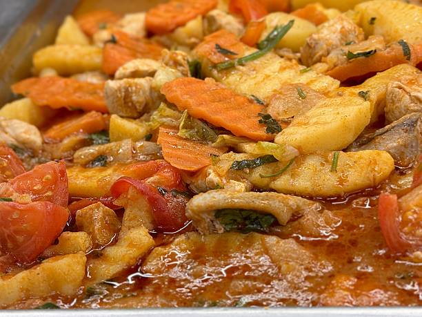 Hearty Meat Vegetable Stew On Market Counter, Vendor Display Of Rich Tomato Broth With Chunky Potatoes, Carrots, Zucchini And Mushrooms, Sprinkled Herbs And Paprika, Steaming Stainless Tray