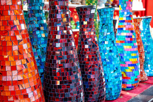 Colored glass vases with red, blue and multicolored mosaic. Art exhibition on the Christmas market. Handmade vase for interior.