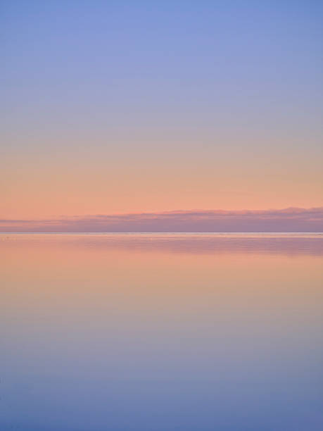 Soft gradient sky blends blue, peach, and pink as the calm sea mirrors the colors along the distant horizon. This peaceful scene conveys quiet reflection, relaxation, and balance, making it suitable for travel, wellness, and nature-themed projects. Ideal for homepage visuals, editorial imagery, and advertising that seeks calm, serene aesthetics. Denmark