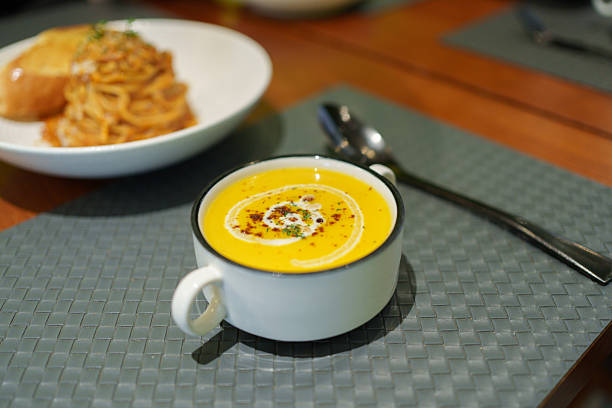 Creamy pumpkin soup placed on the dining table.