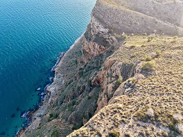 Vast coastal promontory meeting gentle beaches and textured rocky cliffs suitable for adventure