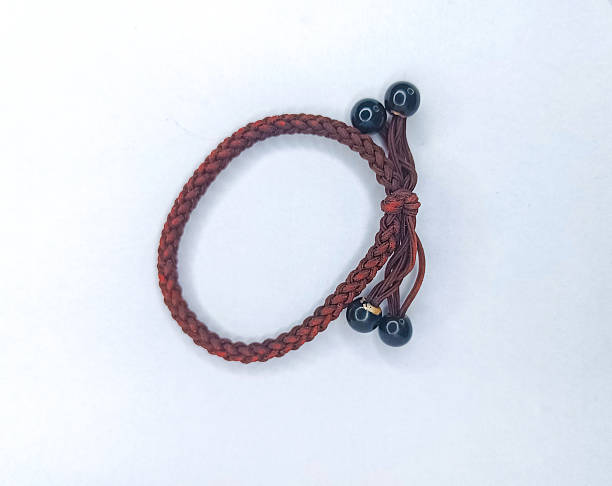 Brown braided hair tie with four shiny black bead charms