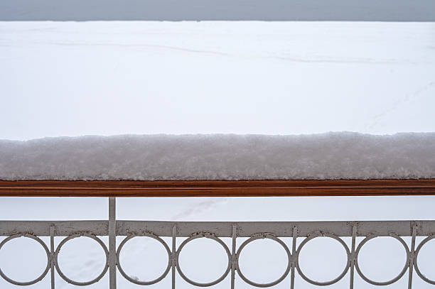 Snow on the balcony railing during heavy snowfall.