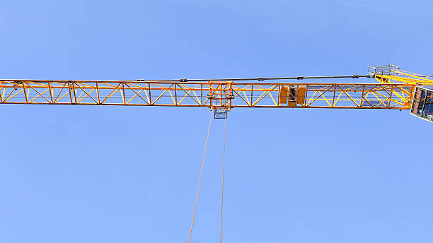 Yellow construction crane, powerful lifting equipment, active building construction, high-lifting operations, mechanization of the construction process, large construction projects and structures