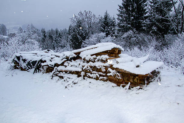 Snowfall in Carinthia, Austria on Christmas Eve 2025. Stacks with gathered firewood for heating the woodstove, covered with snow.