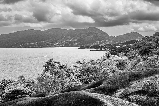 The warm turquoise waters, tropical islands and lagoons of the Seychelles overlooked by the lush rain forest jungle of the interior mountains of La Digue high above La Passe and Praslin. ProPhoto RGB profile for maximum color fidelity and gamut.