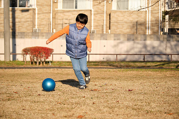 Shot of an adorable little boy holding a soccer ball outside.