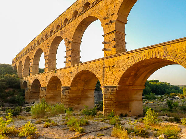 Pont du Gard is an ancient Roman aqueduct bridge over the river Gardon in the French Gard department during a summer sunset