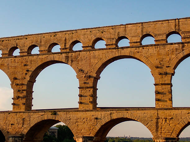 Pont du Gard is an ancient Roman aqueduct bridge over the river Gardon in the French Gard department during a summer sunset